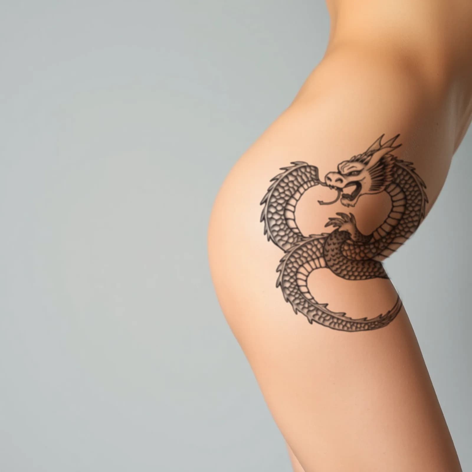 Dragon and Snake Intertwined tattoo shown on the thigh